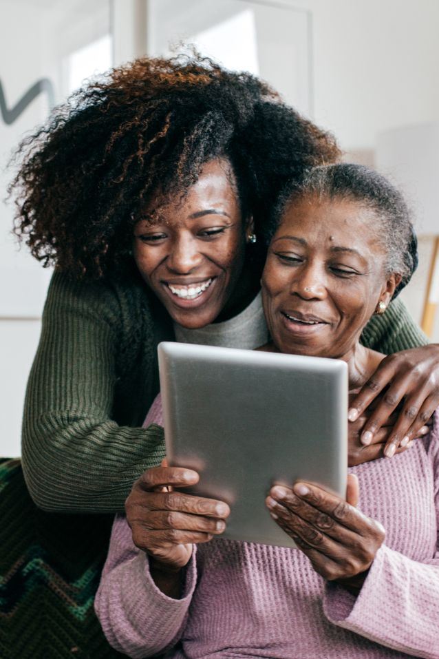 caregiver helping elderly with tablet