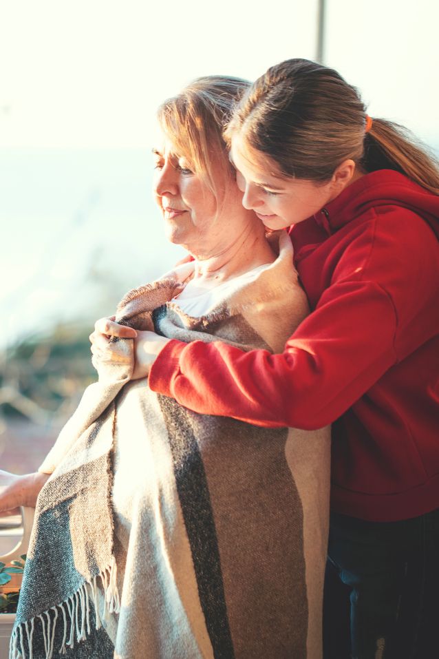 caregiver hugging elderly woman